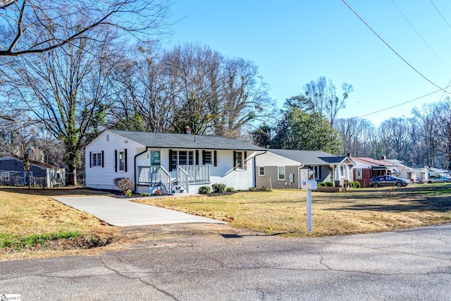 single story home featuring a chimney, a porch, a residential view, driveway, and a front lawn