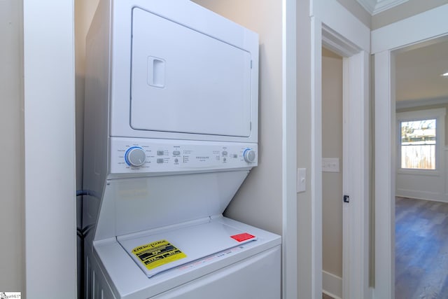 laundry room with stacked washer and dryer, laundry area, and wood finished floors