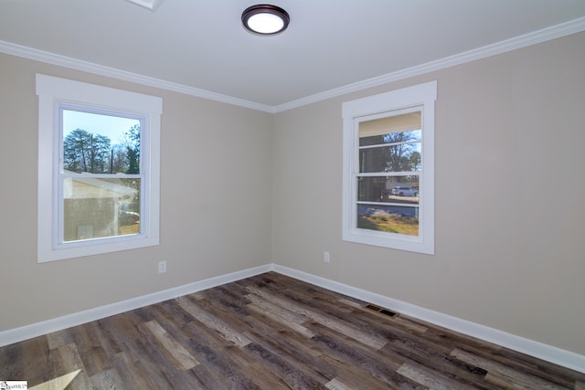 spare room with ornamental molding, dark wood-type flooring, visible vents, and baseboards