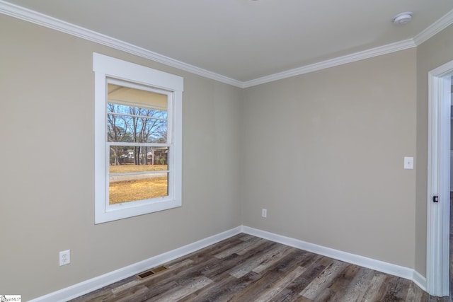 empty room featuring ornamental molding, dark wood-type flooring, visible vents, and baseboards