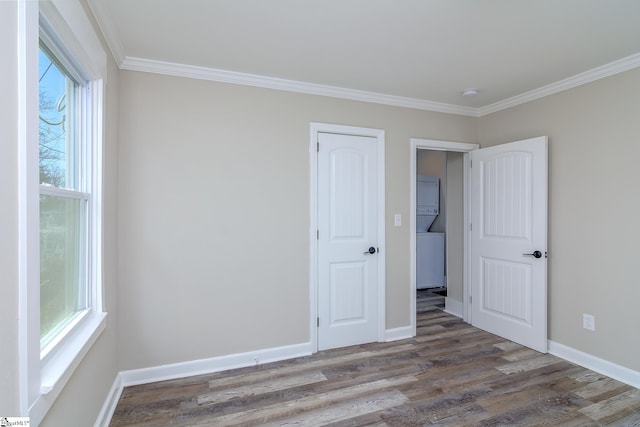 unfurnished bedroom with crown molding, baseboards, and wood finished floors