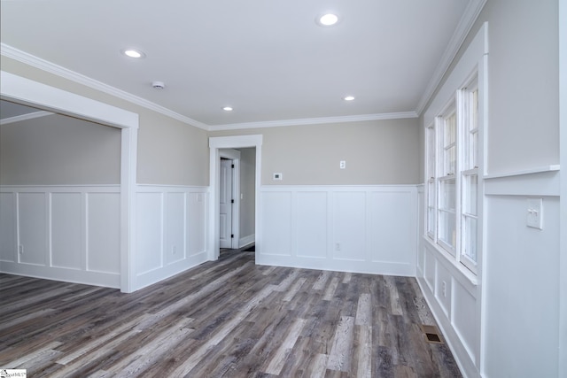 spare room with ornamental molding, recessed lighting, dark wood finished floors, and a decorative wall