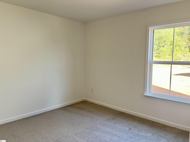 empty room featuring carpet floors and baseboards