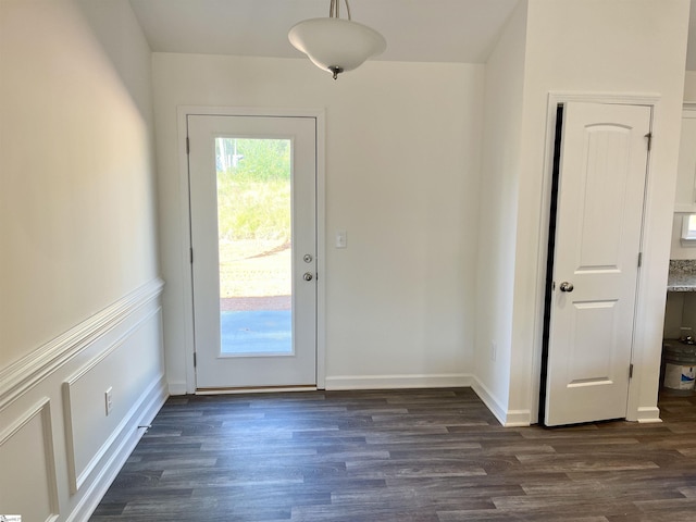 entryway with a wainscoted wall, dark wood-type flooring, and a decorative wall