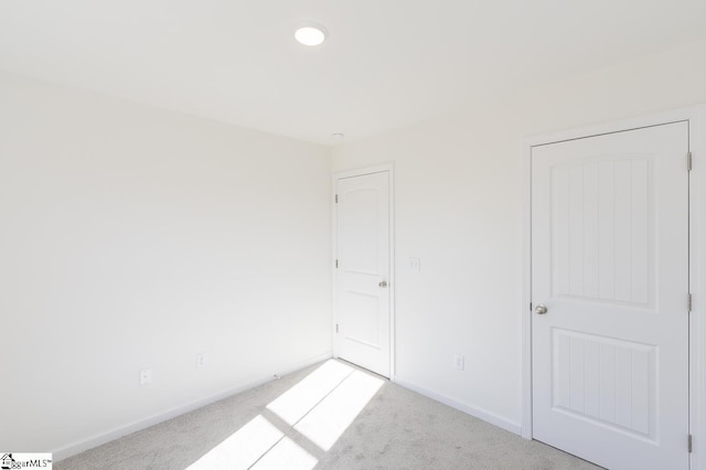 unfurnished bedroom with baseboards and light colored carpet