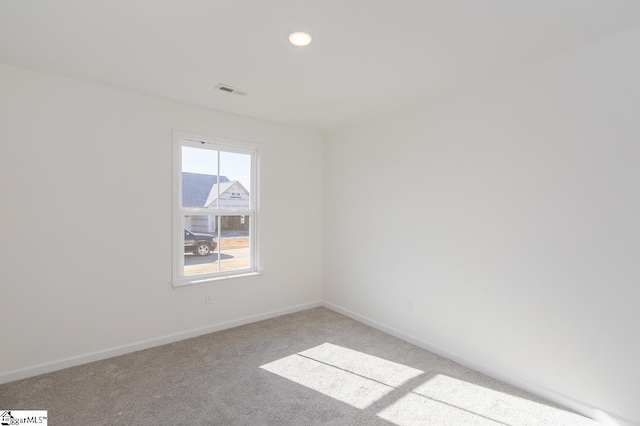 empty room featuring light carpet, recessed lighting, visible vents, and baseboards