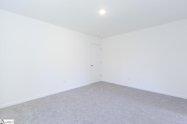 carpeted spare room with baseboards