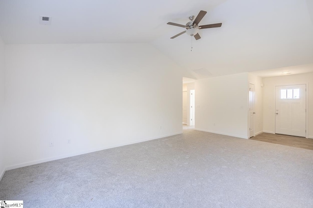 unfurnished living room featuring light carpet, baseboards, visible vents, a ceiling fan, and vaulted ceiling