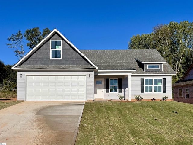 view of front of property with a shingled roof, concrete driveway, an attached garage, and a front lawn