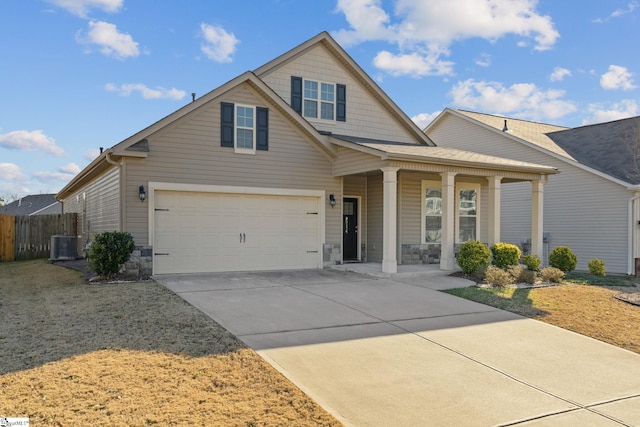 view of front facade featuring a porch, stone siding, an attached garage, and concrete driveway