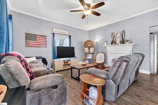 living room with ceiling fan, crown molding, baseboards, and wood finished floors