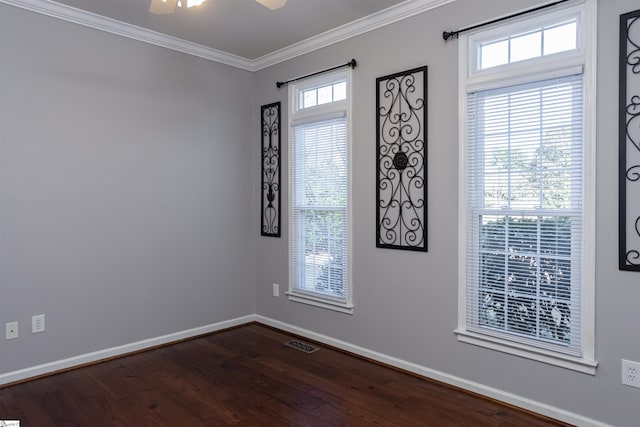 unfurnished room featuring baseboards, dark wood finished floors, visible vents, and crown molding