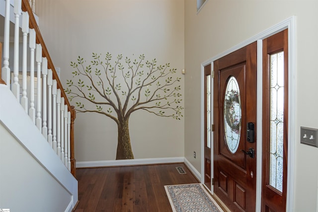 entrance foyer featuring dark wood-style flooring, visible vents, baseboards, and stairs