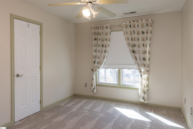 unfurnished room with light carpet, baseboards, visible vents, and ceiling fan