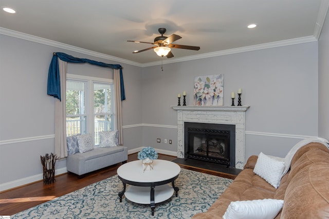 living area featuring a fireplace with flush hearth, dark wood-style flooring, crown molding, and baseboards