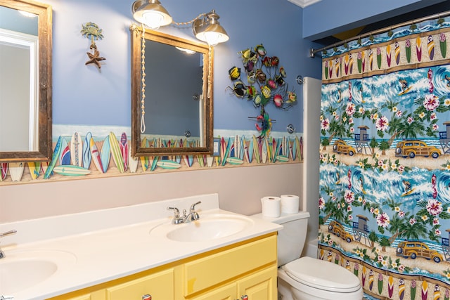 full bathroom with toilet, double vanity, and a sink