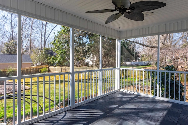 unfurnished sunroom featuring a ceiling fan