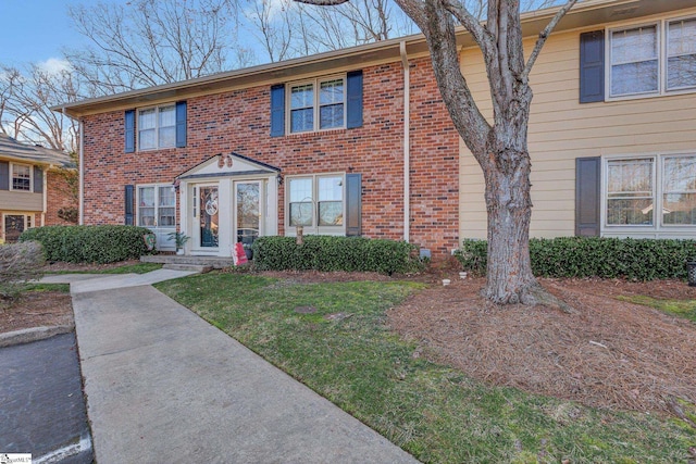 view of front of home featuring a front yard and brick siding