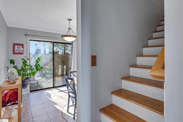 stairway with tile patterned flooring and crown molding