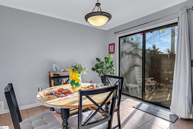 dining room with tile patterned flooring, crown molding, and baseboards