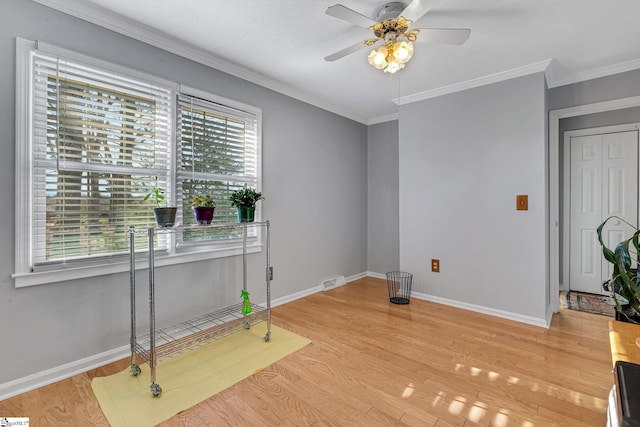 interior space featuring crown molding, light wood-style flooring, and baseboards