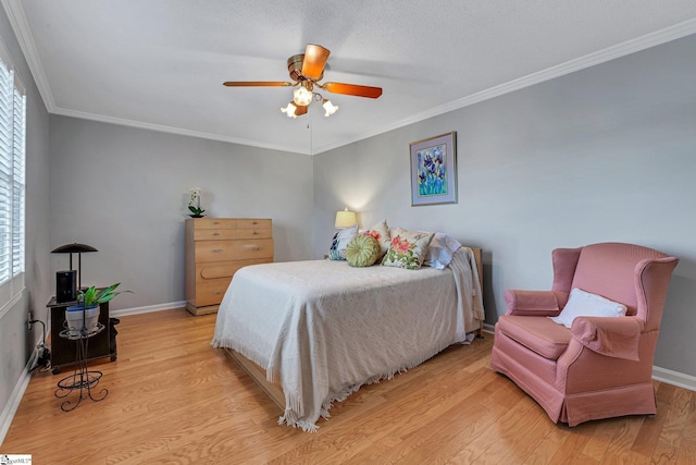 bedroom featuring light wood-style floors, baseboards, and crown molding