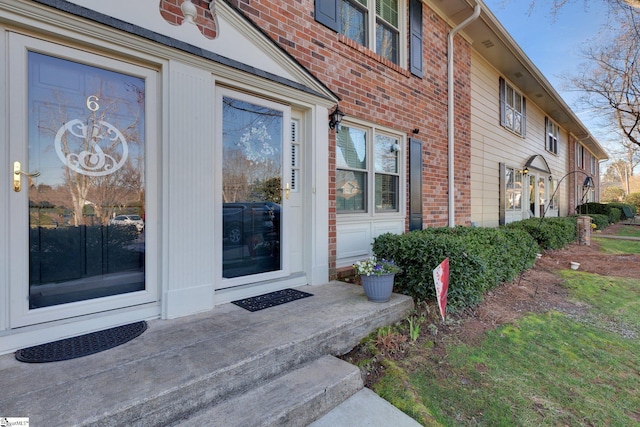 entrance to property featuring brick siding