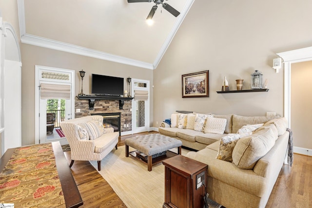 living area featuring light wood-type flooring, high vaulted ceiling, a fireplace, and ornamental molding