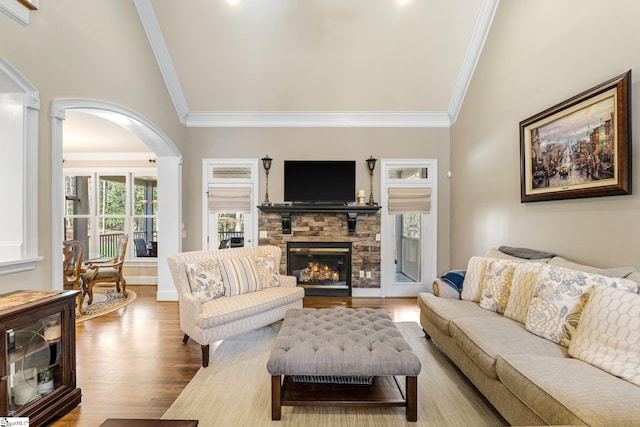 living area with baseboards, light wood finished floors, a fireplace, and crown molding