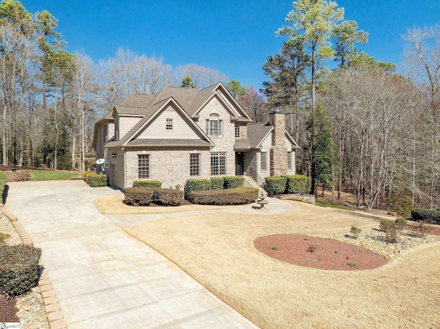 view of front of home with concrete driveway and a shingled roof