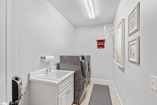 laundry room with baseboards, cabinet space, a sink, and washing machine and clothes dryer