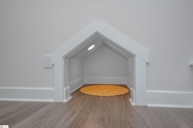 bonus room featuring lofted ceiling, light wood-style flooring, and baseboards