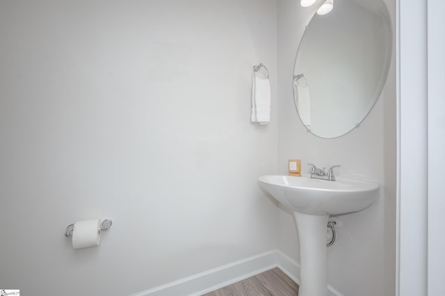 bathroom featuring a sink, baseboards, and wood finished floors