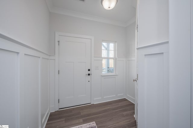 entrance foyer featuring ornamental molding, a wainscoted wall, a decorative wall, and dark wood-style floors