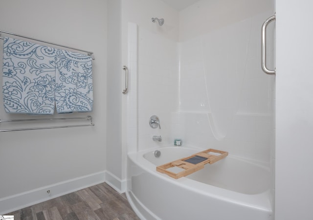 bathroom with shower / bath combination, baseboards, and wood finished floors