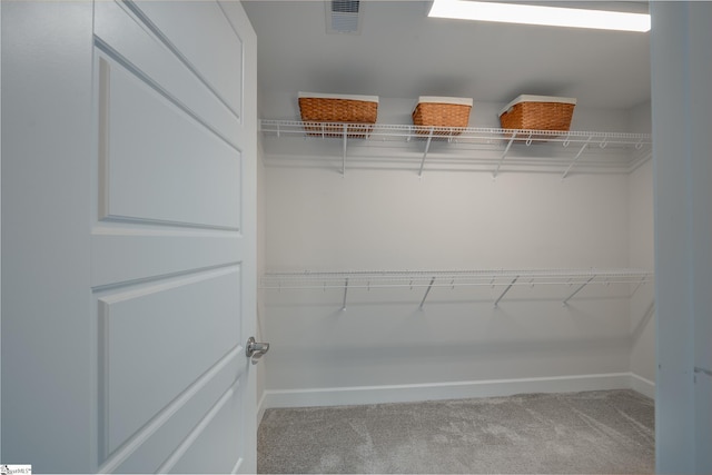 walk in closet with visible vents and light colored carpet