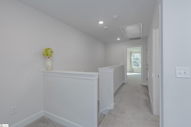 corridor featuring baseboards, visible vents, light colored carpet, and an upstairs landing