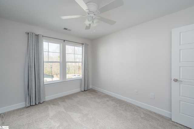 unfurnished room featuring a ceiling fan, light colored carpet, visible vents, and baseboards