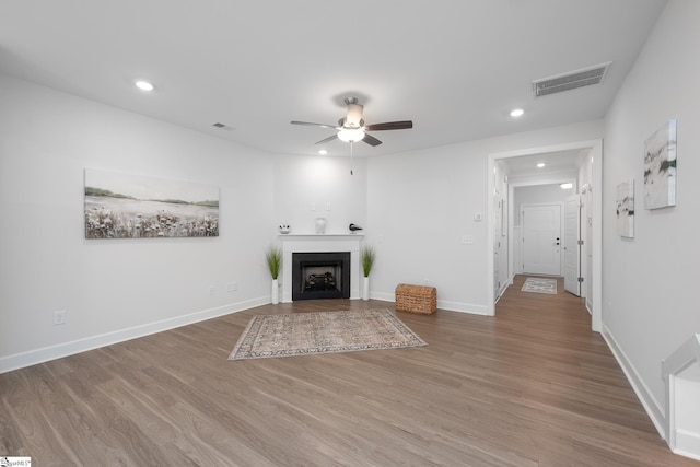 unfurnished living room featuring a fireplace, visible vents, wood finished floors, and recessed lighting