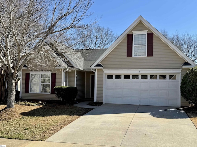 traditional home featuring driveway and roof with shingles