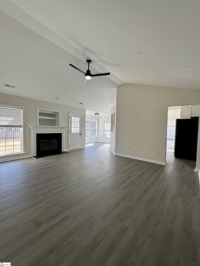 unfurnished living room with a fireplace with flush hearth, vaulted ceiling, ceiling fan, wood finished floors, and baseboards