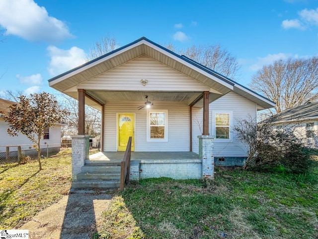 bungalow with fence, a porch, and a front yard