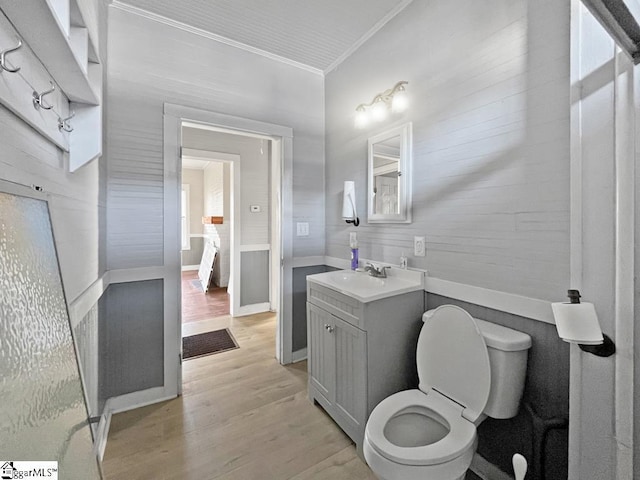 ensuite bathroom with ensuite bathroom, toilet, wood finished floors, vanity, and crown molding