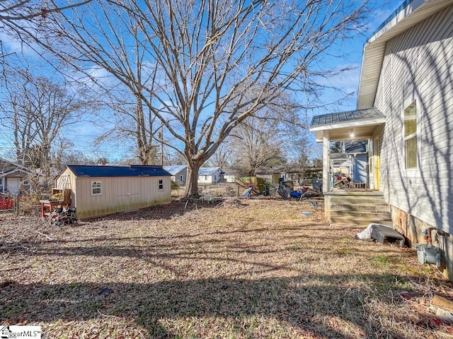 view of yard with an outbuilding, a storage unit, and fence