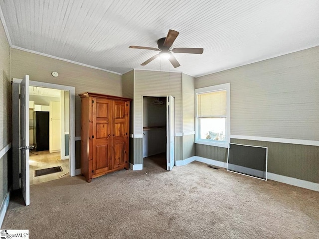 unfurnished bedroom with carpet floors, visible vents, ornamental molding, freestanding refrigerator, and ceiling fan