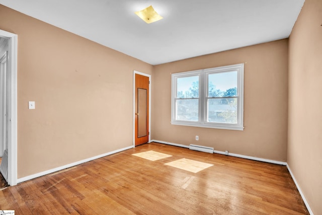 unfurnished room with light wood-type flooring, baseboard heating, and baseboards