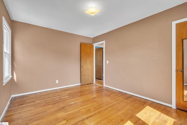 empty room featuring light wood-type flooring and baseboards