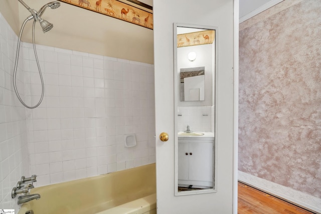 full bathroom with a sink, wood finished floors, and bathtub / shower combination