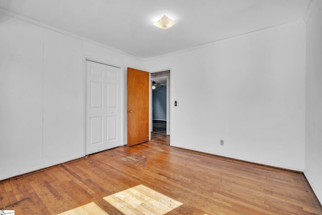 empty room with light wood-type flooring and crown molding