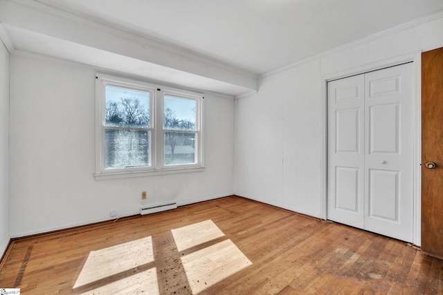 unfurnished bedroom with ornamental molding, a baseboard radiator, a closet, and light wood finished floors